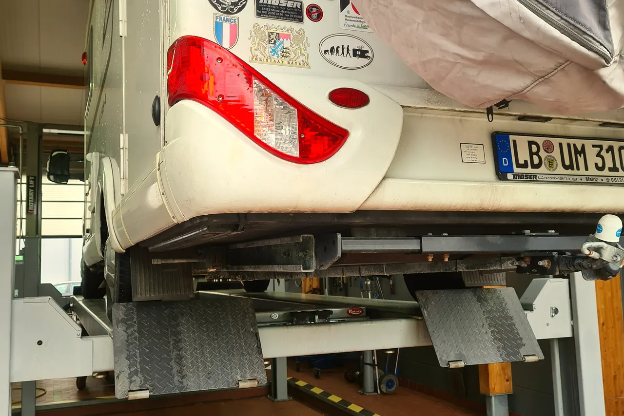 Ein Fahrzeug steht zur Untersuchung angehoben auf der Hebebühne in der Werkstatt von Indlekofer.
